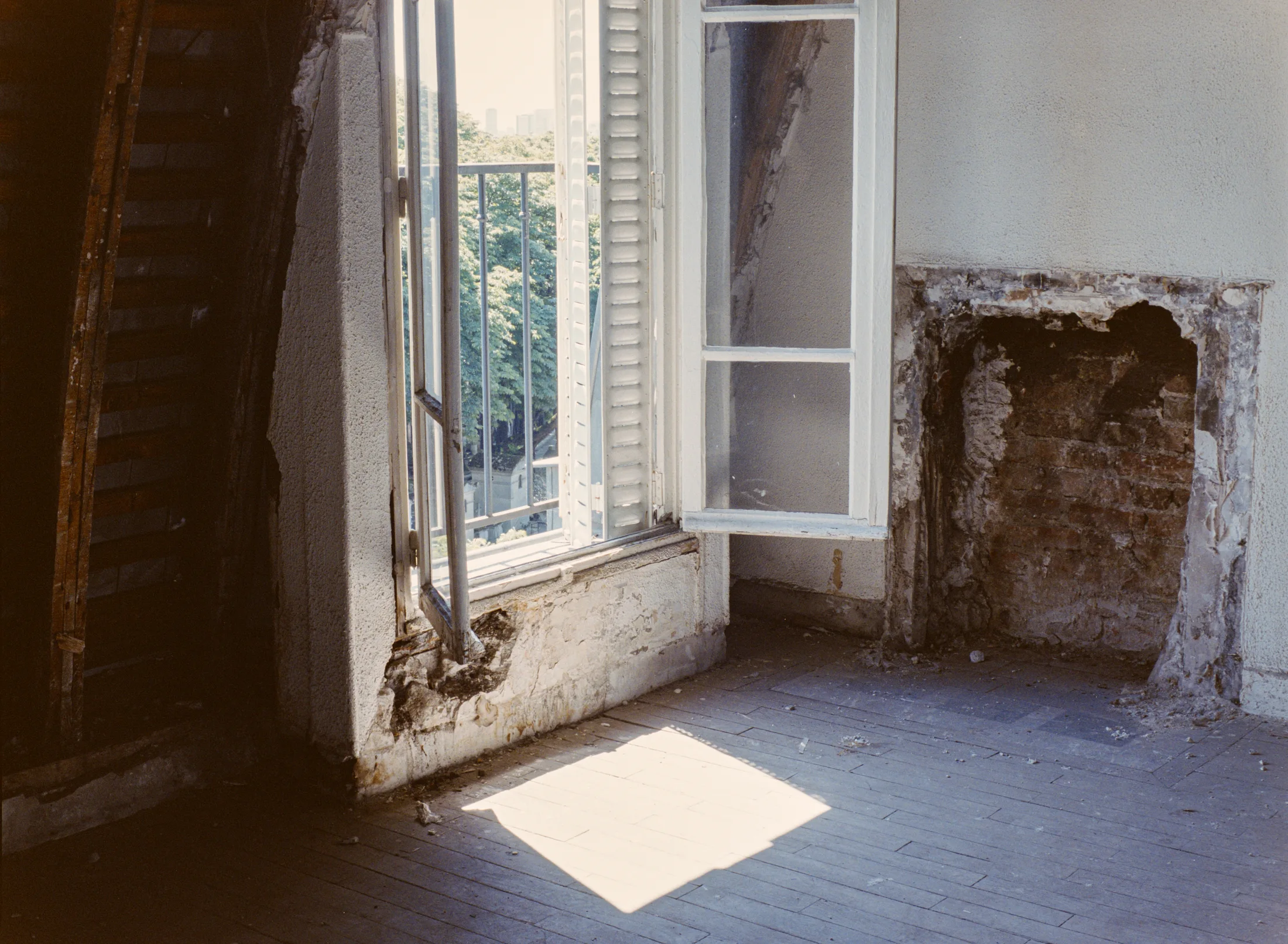 Sunlight falling through an open window onto a bare floor
