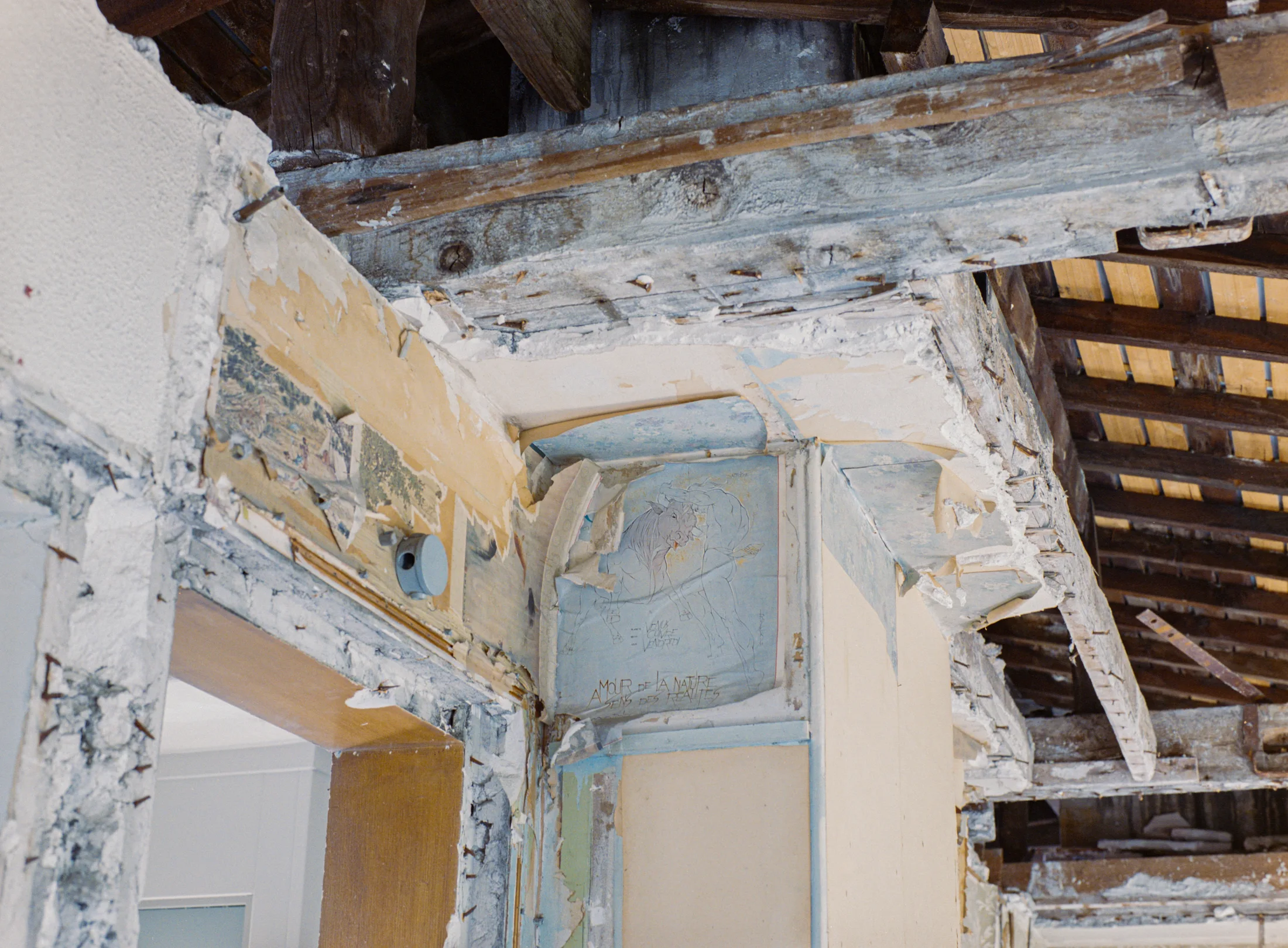 Exposed timber framing above a partially stripped doorway