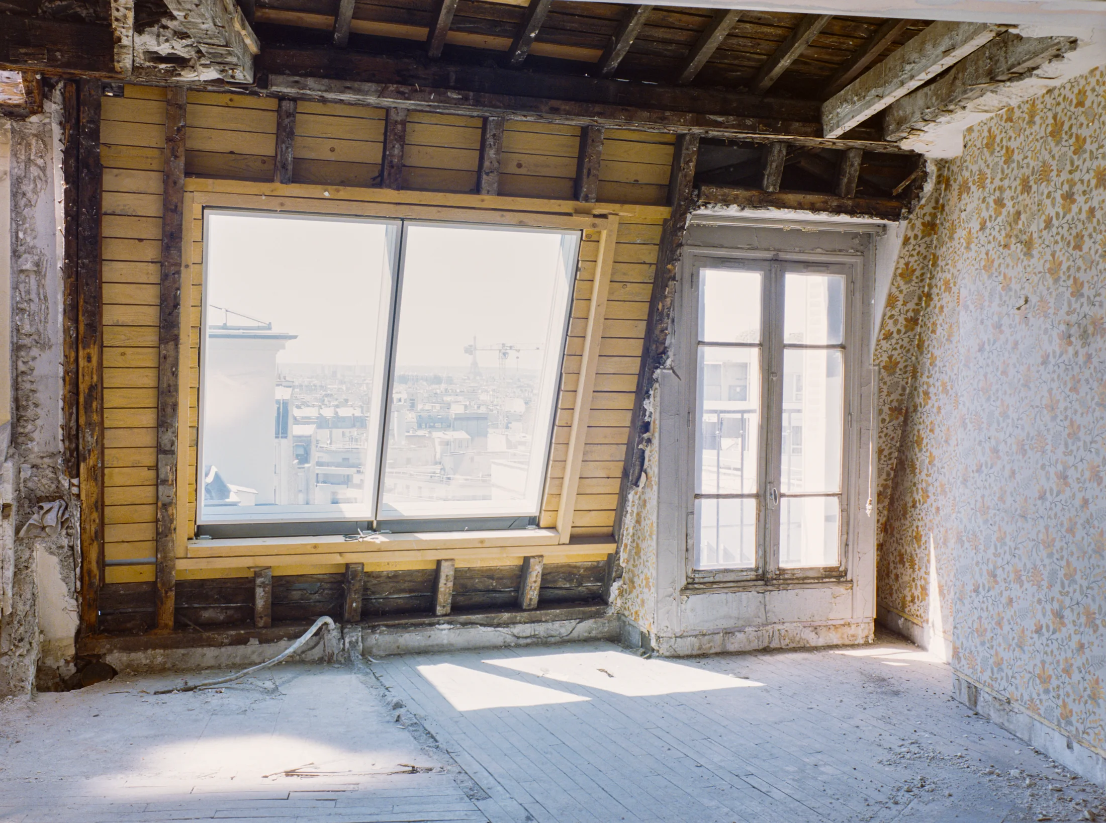 Attic room with two windows and exposed roof and wall framing