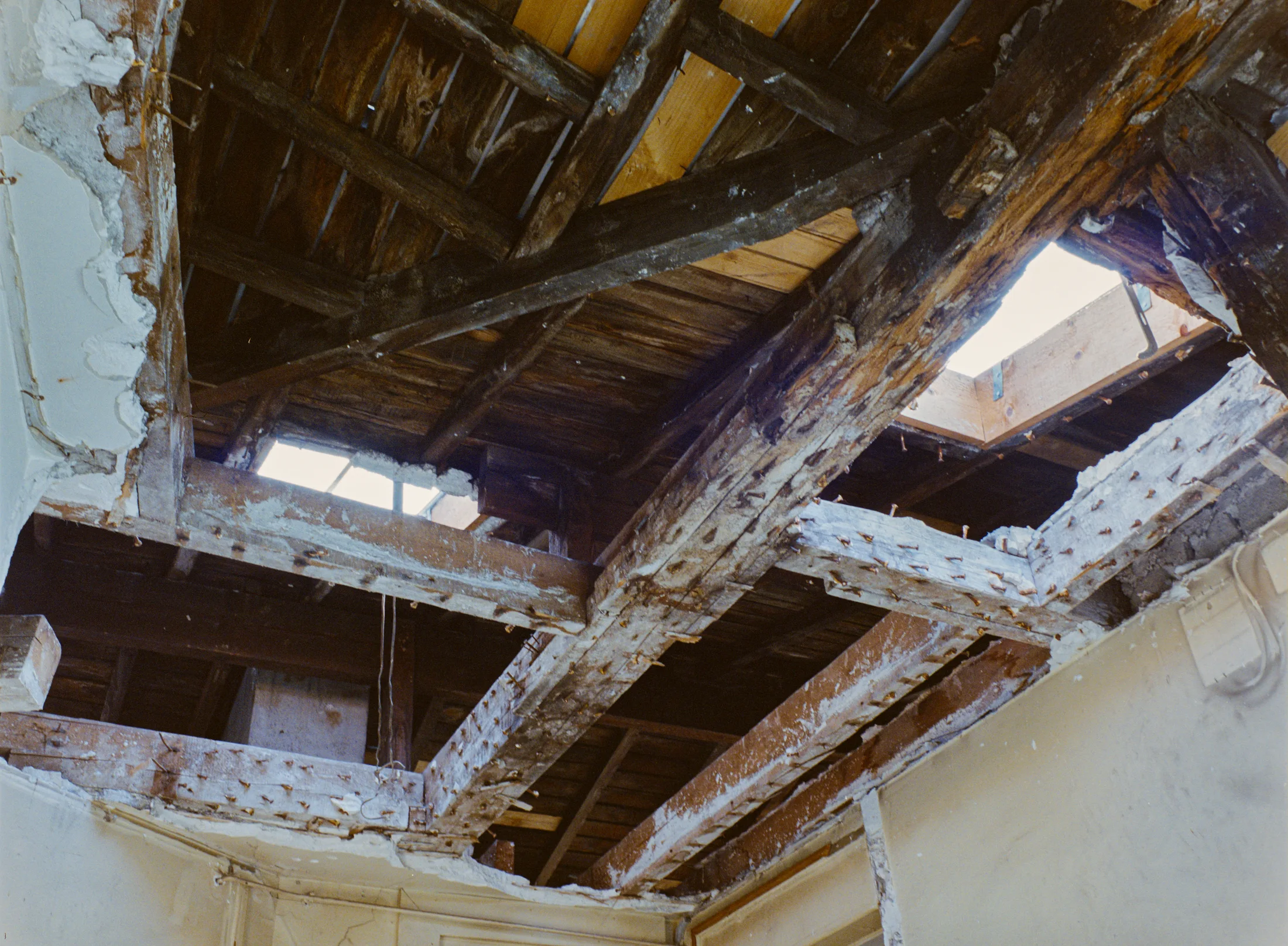 View upward through exposed roof beams and openings